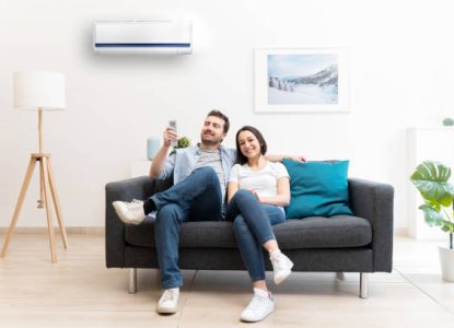 Happy couple freshen up using air conditioner at home